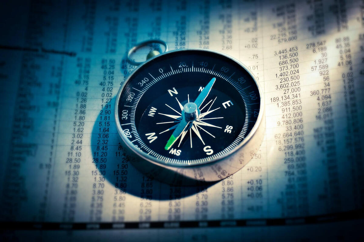 Independent Research Compass on a dark surface representing independent direction and unconflicted analysis